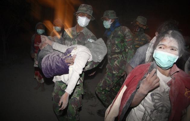Des militaires aident des habitants à évacuer Malang, après l'éruption du Mont Kelud, le 14 février 2014 sur l'île de Java, en Indonésie [Aman Rochman / AFP]