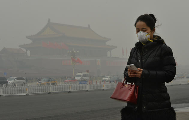 Une Chinoise porte un masque filtrant pour se protéger de la pollution, le 26 février 2014 à Pékin  [Mark Ralston / AFP]