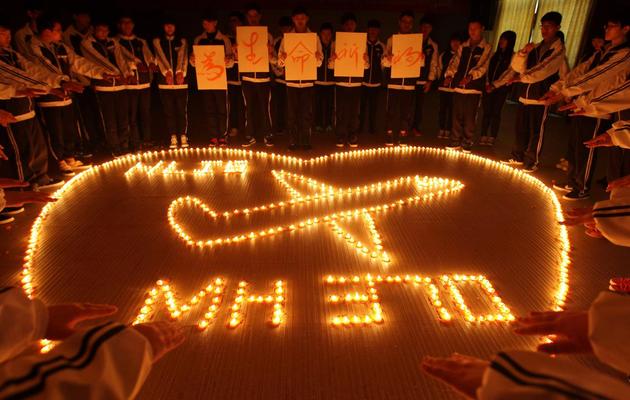 Des étudiants chinois prient pour les passagers du Boeing disparu de Malaysia Airlines, à Zhuji le 10 mars 2014 [ / AFP]