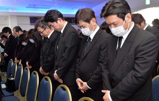 Des Japonais observent une minute de silence en hommage à la mémoire des victimes du tsunami de 2011, à Namie le 11 mars 2014 [Yoshikazu Tsuno / AFP]