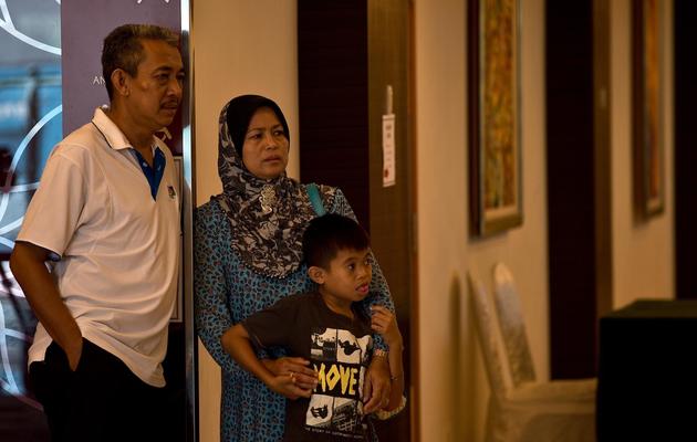 Des proches d'un passager du vol MH370 disparu dans le hall d'un hôtel de Putrajaya le 12 mars 2014 [Manan Vatsyayana / AFP]