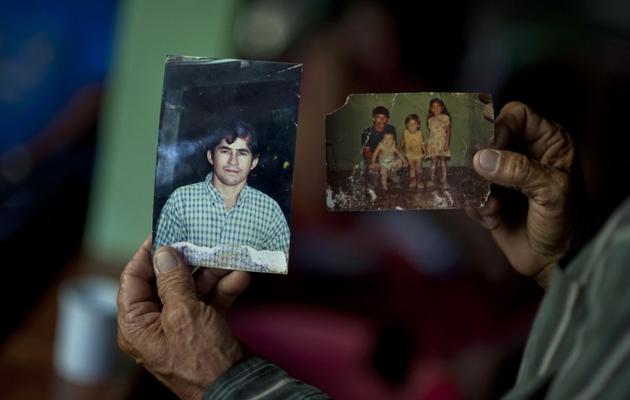 Jose Ricardo Orellana, le père du Salvadorien Jose Salvador Alvarenga, montre des photos de son fils, à Garita Palmera, au Salvador le 4 février 2014 [Jose Cabezas / AFP]
