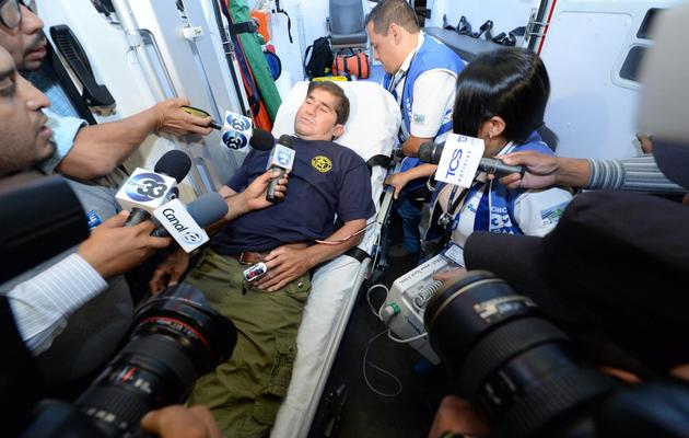 Le naufragé salvadorien José Salvador Alvarenga, installé dans une ambulance pour être conduit à l'hôpital de Santa Tecla, répond aux journalistes, le 11 février 2014 au Salvador [Marvin Recinos / AFP]