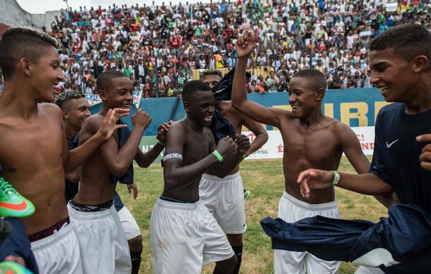 Les joueurs de Vila Kennedy célèbrent leur victoire contre Cidade de Deus, en finale de la Coupe des favelas, le 15 février 2014 à Rio de Janeiro [Yasuyoshi Chiba / AFP]