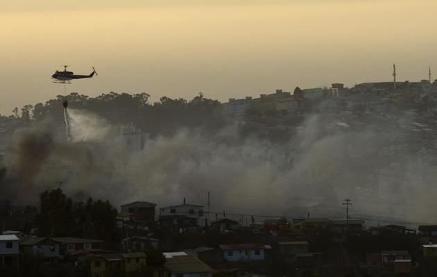 Un hélicoptère combat le 13 avril 2014 le gigantesque incendie qui ravage Valparaiso  [Martin Bernetti / AFP]