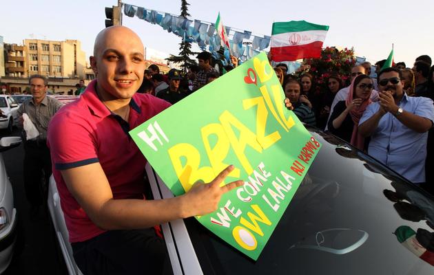 Un Iranien fête la qualification de l'Iran pour le mondial au Brésil le 18 juin 2013 à Téhéran [ATTA KENARE / AFP Photo]