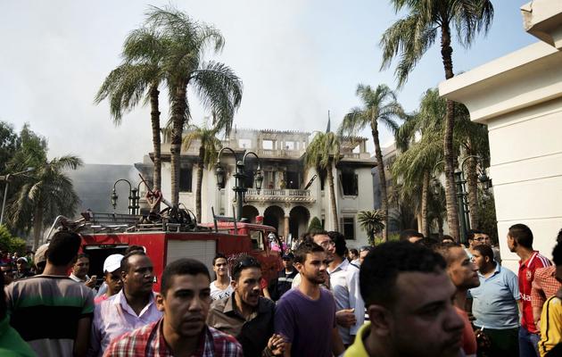 Des pompiers et des passants se pressent devant le siège du gouvernorat de Gizeh, incendié, le 15 août 2013 au Caire [Gianluigi Guercia / AFP]