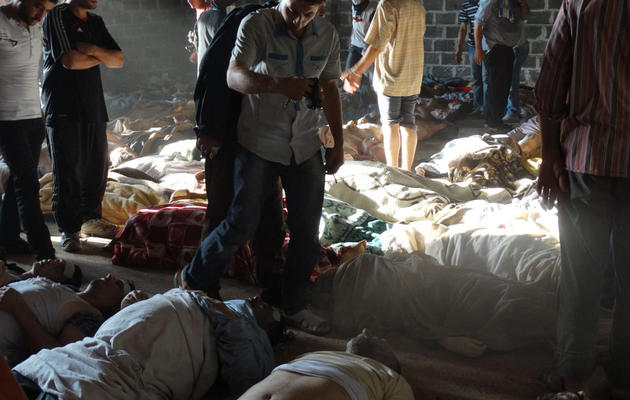 Photo de l'opposition syrienne montrant des personnes en train d'examiner des cadavres d'adultes et d'enfants qui auraient été victimes d'armes chimiques lors de bombardements de l'armée près de Damas, le 21 août 2013 [- / Shaam News Network/AFP]