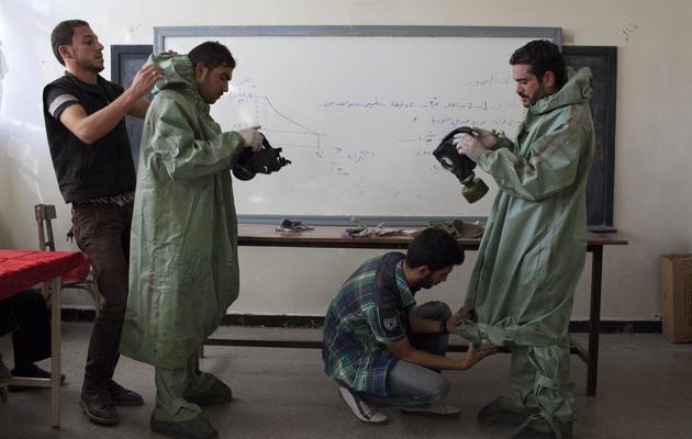 L'étudiant Mohammad Zayed (2e d) montre à des civils syriens comment utiliser des masques à gaz en cas d'attaque chimique, le 15 septembre 2013 à Alep  [Jm Lopez / /AFP]