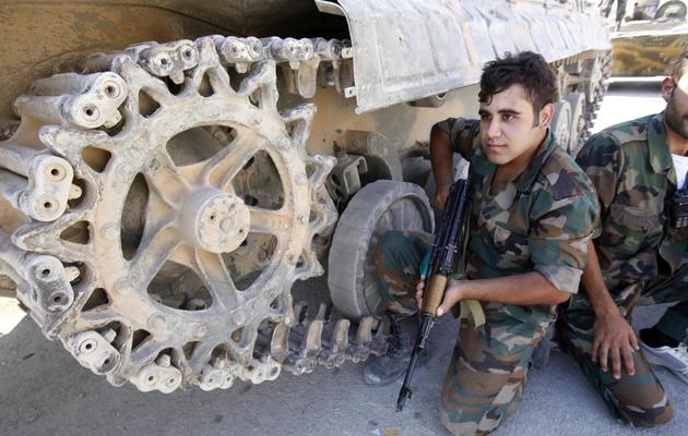 Des soldats syriens adossés à un tank, le 18 septembre 2013 à Maaloula [Anwar Amro / AFP]