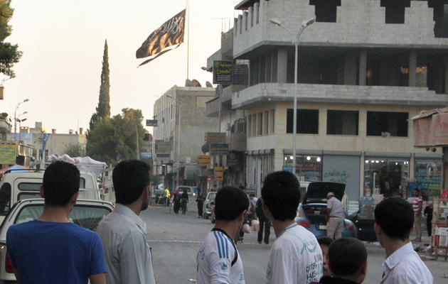 Des jihadistes font flotter leur drapeau sur la ville de Raqqa, le 28 septembre 2013 [Mohammed Abdul Aziz / /AFP/Archives]