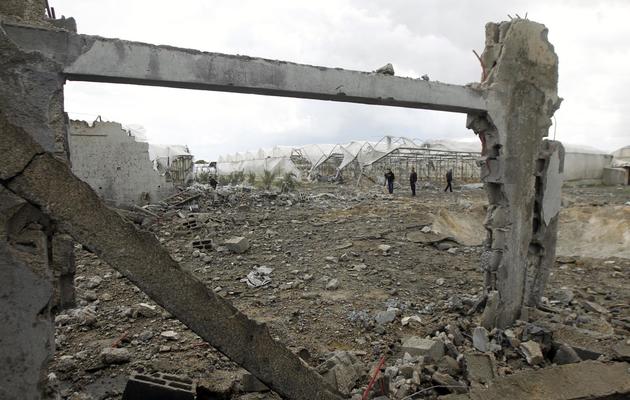 Des Palestiniens inspectent les dégâts après des frappes aériennes d'Israël, le 14 mars 2014 à Rafah [Said Khatib / AFP]