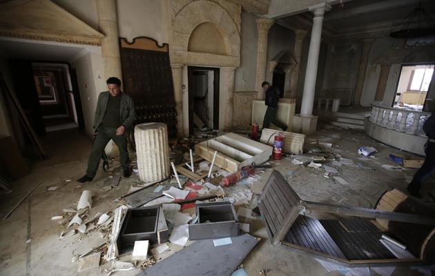 Des policiers syriens inspectent le rez-de-chaussée du Zénobia, hôtel de légende construit dans les années 1920 par une aventurière française sur l'ancien site de Palmyre, qui a été pillé et à moitié brûlé, le 14 mars 2014 [Joseph Eid / AFP]