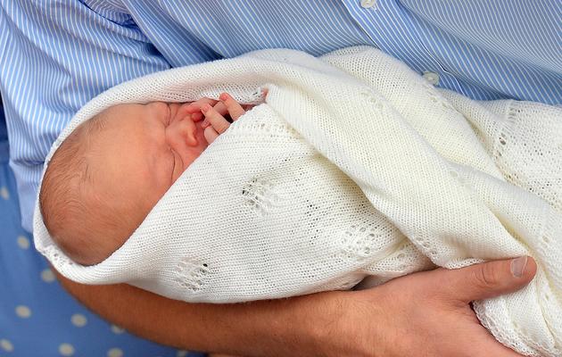 Le prince William tient son fils dans ses bras devant l'hôpital St Mary, le 23 juillet 2013 à Londres [John Stillwell / POOL/AFP]