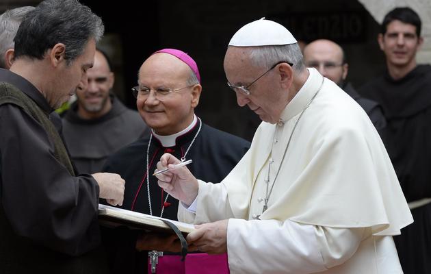 Le pape signe un livre le 4 octobre 2013 lors de sa visite au monastère d'Assise [Andreas Solaro  / POOL/AFP]