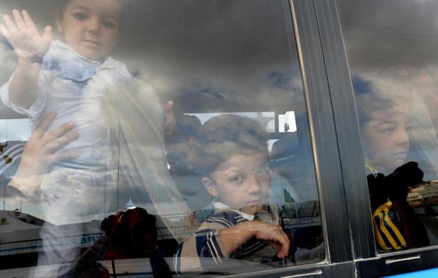 Des enfants  rescapés du naufrage d'un bateau de migrants, à leur arrivée le 4 octobre 2013 dans le port de Lampedusa [Alberto Pizzoli / AFP]