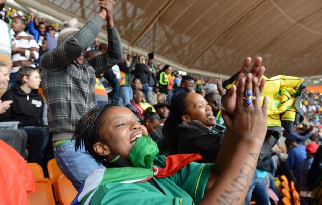 La foule danse et chante pendant la cérémonie d'adieu à Mandela le 10 décembre 2013 au stade Soccer City de Soweto  [Roberto Schmidt  / AFP]