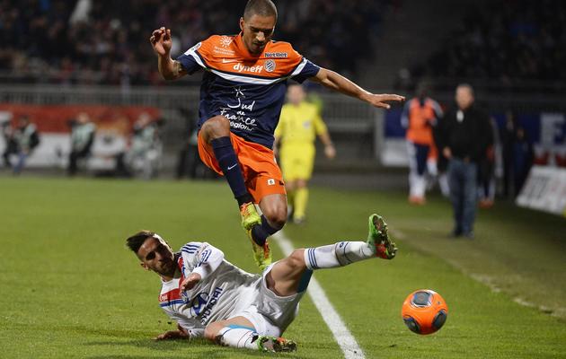 Le milieu de Montpellier Joris Marveaux (en haut) évite le tacle du défenseur de Lyon Miguel Lopes, le 2 mars 2014 à Gerland [Jeff Pachoud / AFP]