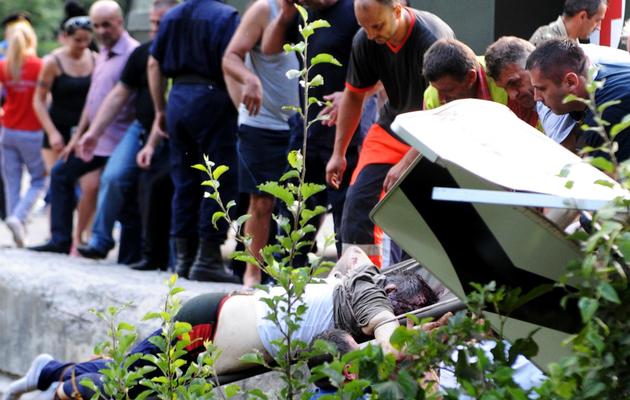 Un blessé est transporté vers une ambulance après un accident d'autocar qui a coûté la vie à 16 Roumains au Monténégro, le 23 juin 2013 [Savo Prelevic / AFP]