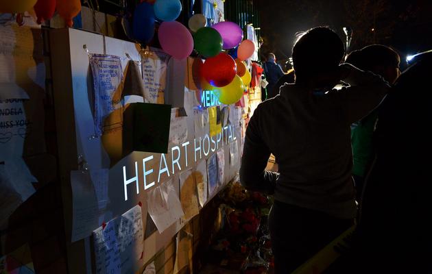 Des personnes déposent des cadeaux et des messages devant l'hôpital où se trouve Nelson Mandela à Pretoria, le 25 juin 2013 [Carl De Souza / AFP]