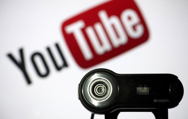 Une webcam positionnée devant le logo du site de partage de vidéos Youtube [Lionel Bonaventure / AFP/Archives]