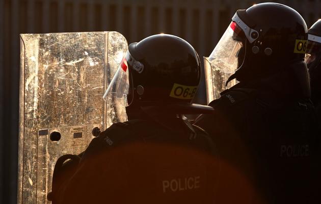 Des policiers se protègent contre des tirs de projectiles des manifestants protestants à Belfast, le 13 juillet 2013 [Peter Muhly / AFP/Archives]