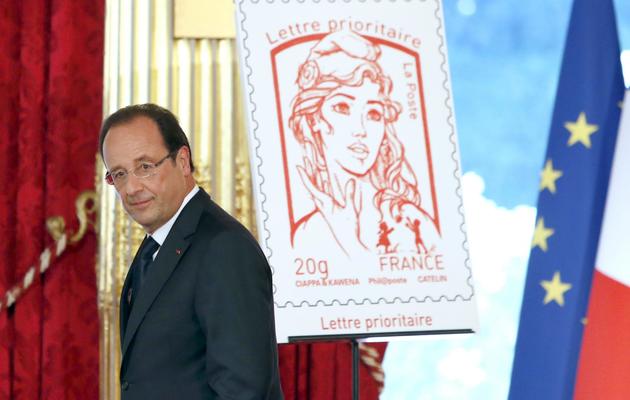 Le président François Hollande, le 14 juillet 2013 à Paris, dévoile le nouveau timbre Marianne [François Mori / Pool/AFP]