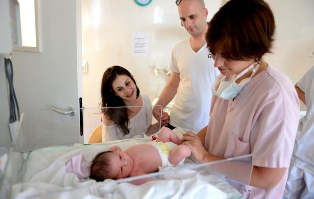 Une sage-femme prend soin du bébé de Hélène Cordeau et de Steven Le Gouallec, après l'accouchement le 2 août 2013 à la Maternité des Lilas, dans la banlieue parisienne [ERIC FEFERBERG / AFP]