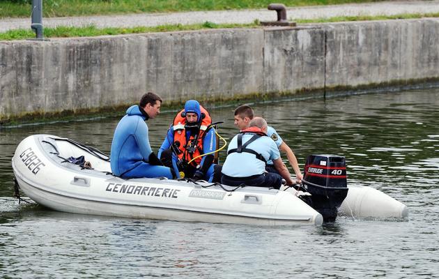 Des gendarmes sur le canal de la Deûle où été retrouvé le corps d'une fillette de 3 ans, le 17 août 2013 [Philippe Huguen / AFP]