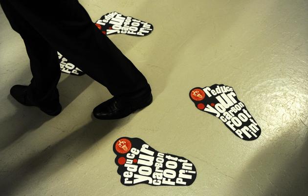 Des stickers appelant à "réduire votre empreinte écologique"  dans les allées de la Conférence de Copenhague sur le climat, le 10 décembre 2009 [ADRIAN DENNIS / AFP/Archives]
