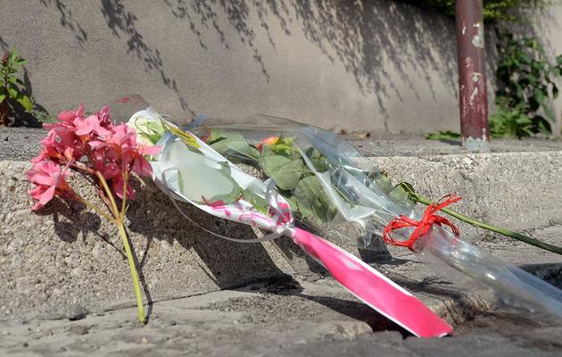 Des fleurs déposées le 23 août 2013 sur un trottoir de Marignane en hommage au retraité tué lors du braquage [Boris Horvat / AFP]