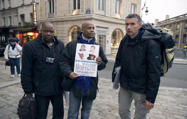 Frédéric Cauhape (d), beau-frère de l'otage Marc Feret, pose avec des proches d'une autre personne kidnappée, le 16 septembre 2013 à Paris, lors d'une marche symbolique [Lionel Bonaventure / AFP]
