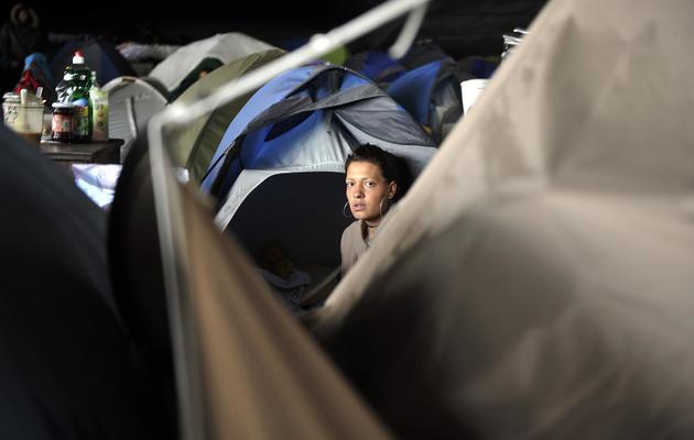 Une femme sortant de sa tente dans un camp de demandeurs d'asile albanais, près de la gare Perrache, à Lyon, le 11 octobre 2013 [Romain Lafabregue / AFP]