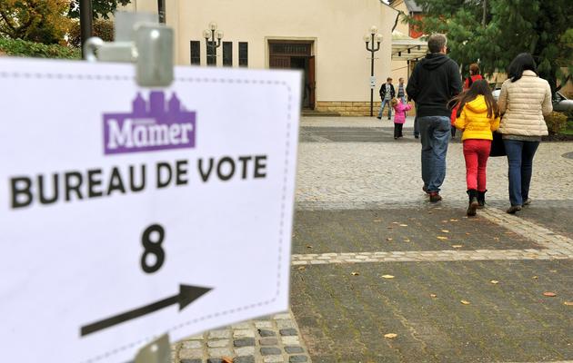 Des citoyens suisses se dirigent vers des bureaux de vote, le 20 octobre 2013 à Luxembourg [Georges Gobet / AFP]