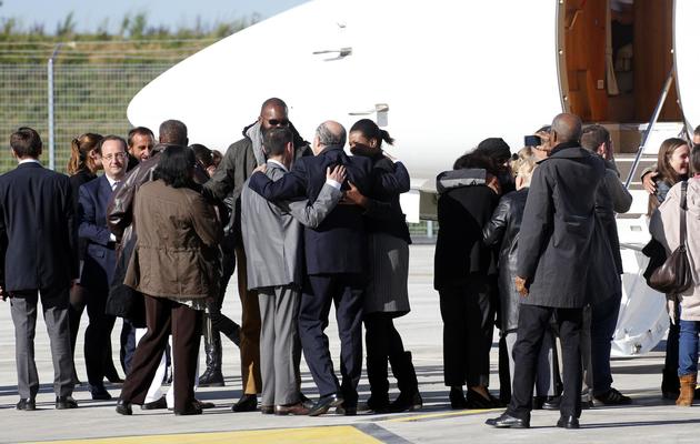 Les ex-otages accueillis par François Hollande (G) et leurs proches à leur arrivée le 30 octobre 2013 à l'aéroport militaire de Villacoublay [François Guillot / AFP]