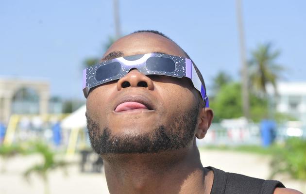 Un homme observe l'éclipse solaire à Libreville, au Gabon [Steve Jordan / AFP]