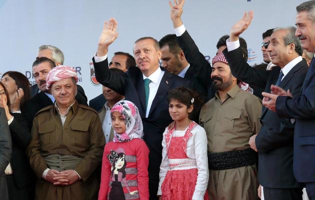 Recep Tayyip Erdogan (c), Massoud Barzani (2e à gauche) et le chanteur kurde Sivan Perwer (3è à droite) saluent le public le 16 novembre 2013 dans la ville turque de Diyarbakir, au sud-est du pays [Mehmet Engin / AFP]