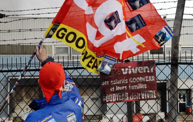 Un salarié agite un drapeau de la CGT devant l'usine Goodyear d'Amiens, le 5 décembre 2013, après l'annonce de la fermeture du site [Denis Charlet / AFP/Archives]