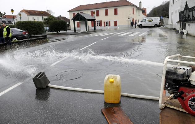 Une pompe dans les rues de Bizanos, dans le Piemont pyrénéen, très touchée par les inondations de samedi - [Luke Laissace / AFP]