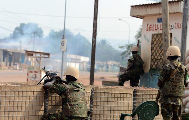 Des soldats rwandais de la Misca regardent une maison brûler à Bangui, le 9 février 2014 [Issouf Sanogo / AFP]