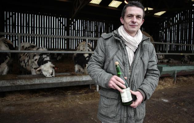 Le fermier français François-Xavier Craquelin et sa bouteille de cidre devant ses boeufs à Villequier le 14 février 2014 [Charly Triballeau / AFP]