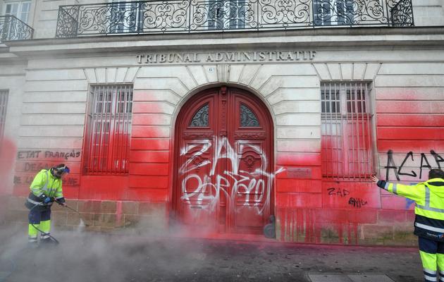 Des employés municipaux nettoient des tags sur la façade du tribunal administratif de Nantes, le 23 février 2014 [Frank Perry / AFP]