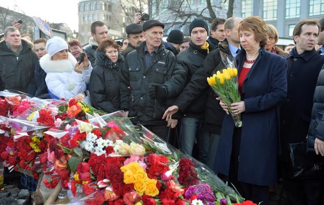 La chef de la diplomatie européenne Catherine Ashton dépose des fleurs en hommage des victimes des barricades, le 24 février 2014 à Kiev [Sergei Supinsky / AFP]