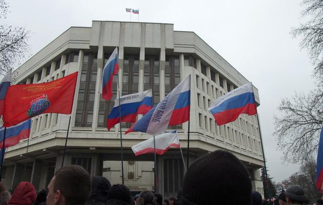 Des pro-Russes manifestent devant le Parlement de Crimée sur lequel flotte le drapeau russe, le 27 février 2014 à Simféropol [Vasily Batanov / AFP]