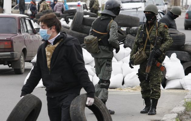 Des activistes pro-russes controlent les véhicules sur la route Kharkiv-Donetsk le 12 avril 2014 à l'entrée de Slaviansk [Anatoliy Stepanov  / AFP]