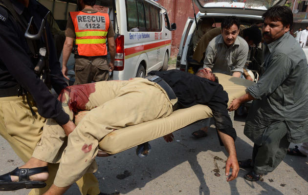 Un homme blessé dans un double attentat suicide, le 22 septembre 2013 à Peshawar, au Pakistan [A. Majeed / AFP]