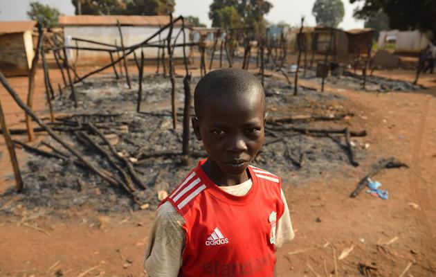 Un enfant devant sa maison brûlée par l'ex-Seneka, à Bogoura, à une soixantaine de km au nord de Bangui, le 19 janvier 2014 [Eric Feferberg / AFP]
