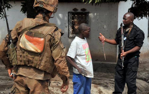 Un soldat français de l'opération Sangaris et un gendarme centrafricain confisquent un couteau à un homme, le 9 février 2014 à Bangui [Issouf Sanogo / AFP]