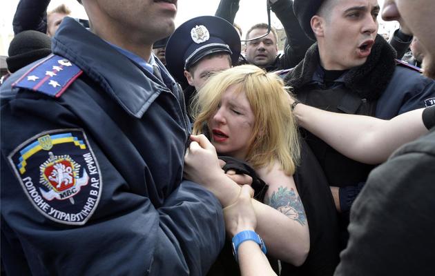 Des policiers ukrainiens arrêtent une manifestante du mouvement Femen, le 6 mars 2014 à Simféropol, la capitale de la Crimée [Alexander Nemenov / AFP]