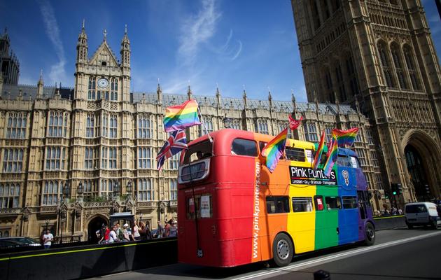 Un bus décoré aux couleurs des partisans du mariage homosexuel passe devant le Parlement britannique, à Londres, le 15 juillet 2013 [Andrew Cowie / AFP]